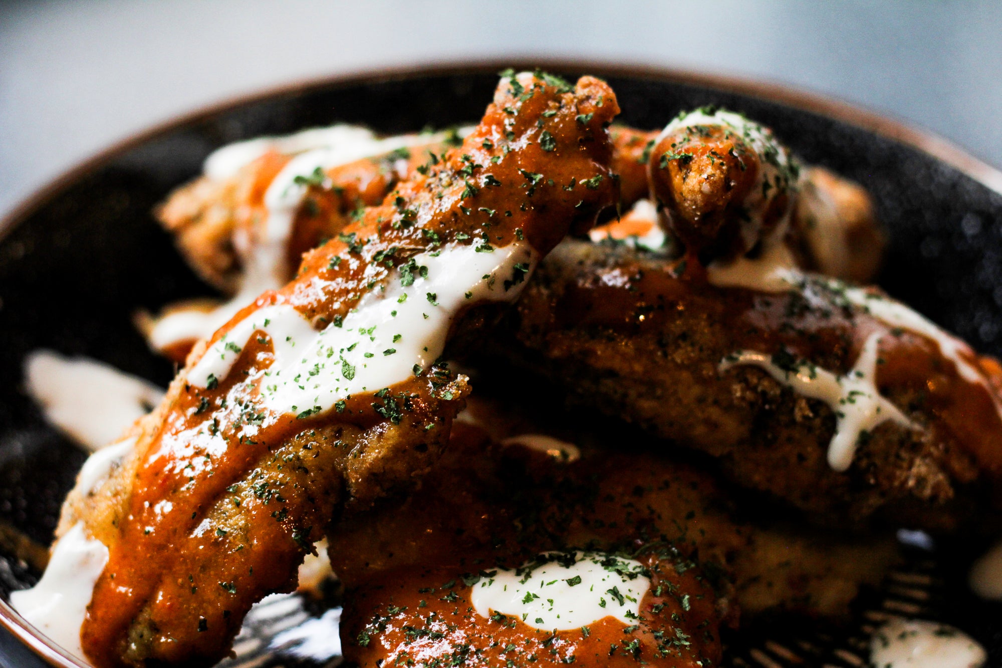 Southern fried chicken strips with Smokey Buffalo sauce on a bed of cheesy hash browns